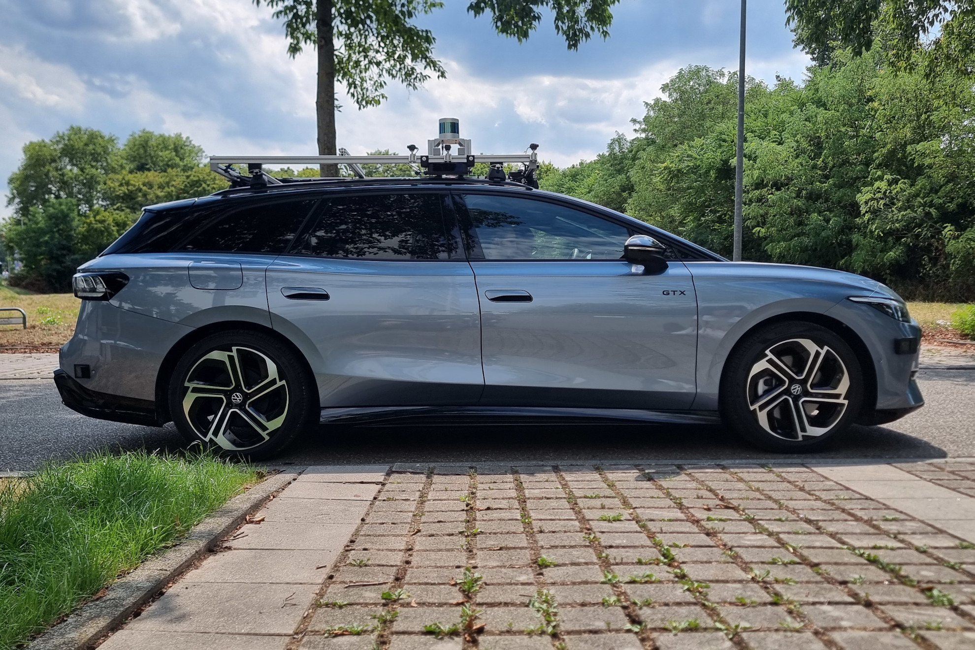Side view of the KE:SAI VW ID.7 research vehicle with its roof-mounted sensor rack.